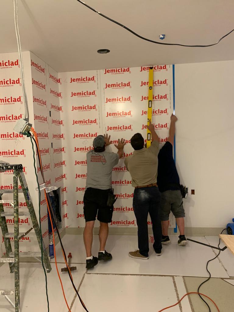 Three Men Fixing Up a PVC Wall